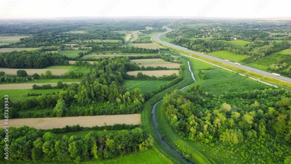 Drone flies around river Ub surrounded by greenery and agricultural fields in Serbia