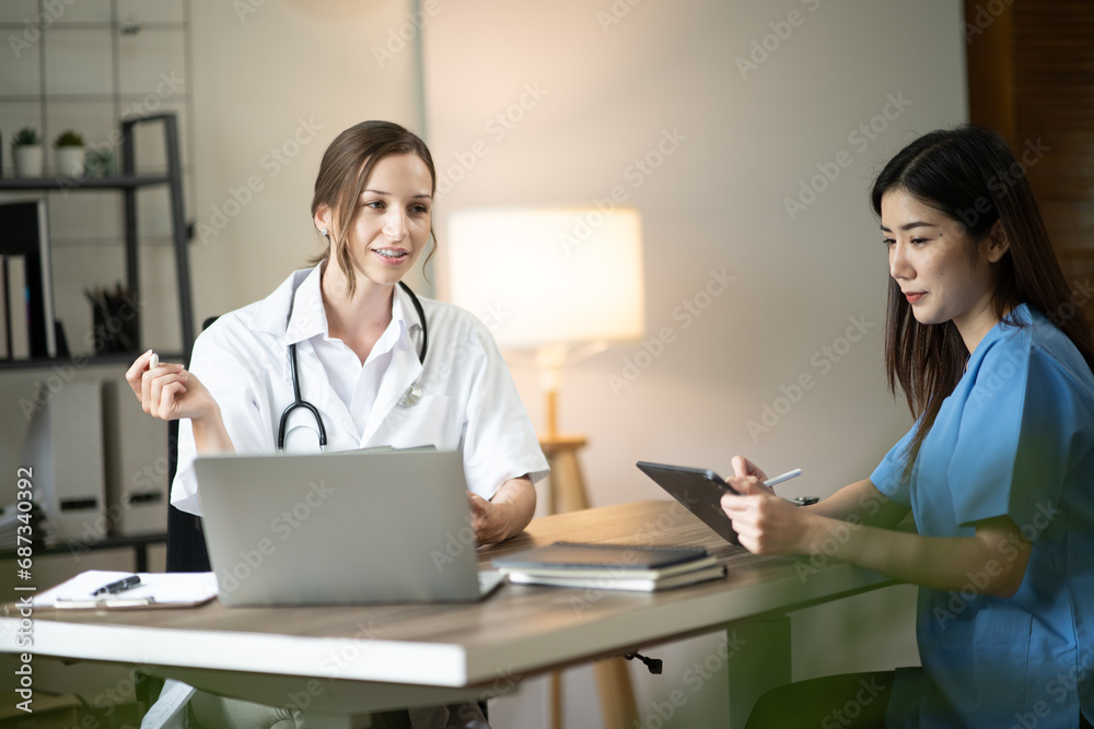 Female doctor sitting at work looking at the history of patients in the clinic or in the hospital