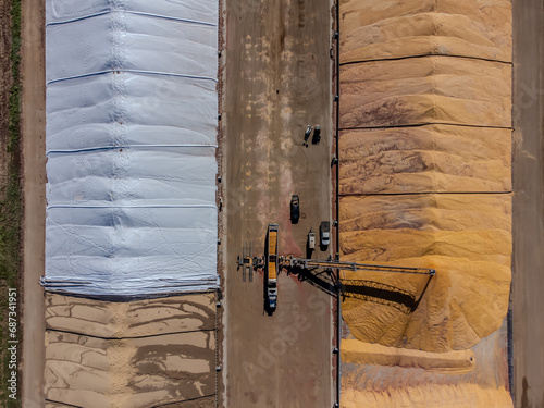Tablou pe pânză Drone view over grain storage piles being filled and covered