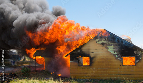 Картината върху платно Firemen battle a house blaze that has consumed the entire building'