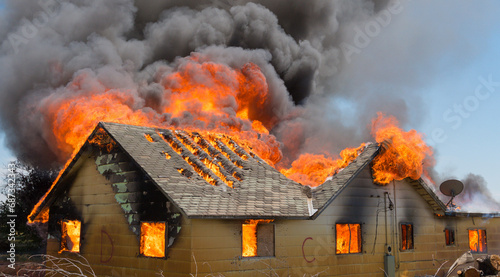 Fotografie Firemen battle a house blaze that has consumed the entire building'