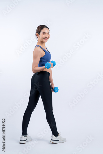 Vigorous energetic woman doing dumbbell weight lifting exercise on isolated background. Young athletic asian woman strength and endurance training session as body workout routine. © Summit Art Creations