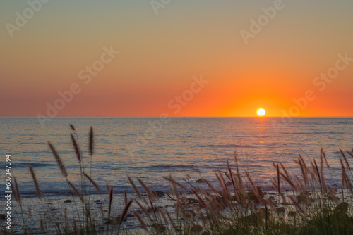 The sun hidding behind the ocean photo