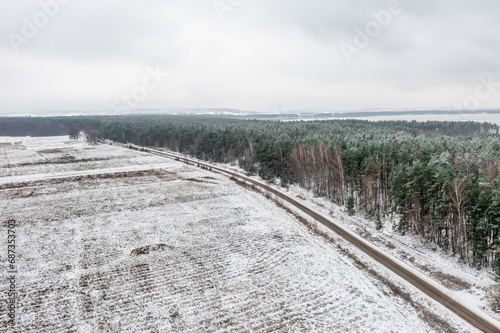Beautiful aerial picture of a winter forest next to a road, Lithuania