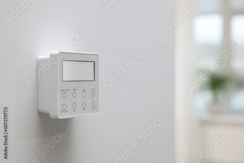 One thermostat on white wall indoors, space for text. Smart home system