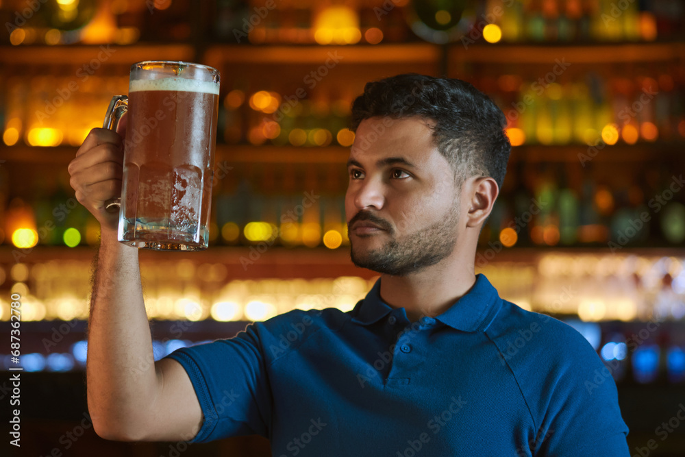 Hombre latino con una cerveza en un bar con colores calidos. con espacio para copy y diseños con expresiones 