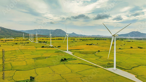 Panoramic view of wind farm or wind park, with high wind turbines for generation electricity with copy space on rice field, Ninh Thuan, Vietnam. Green energy concept.
