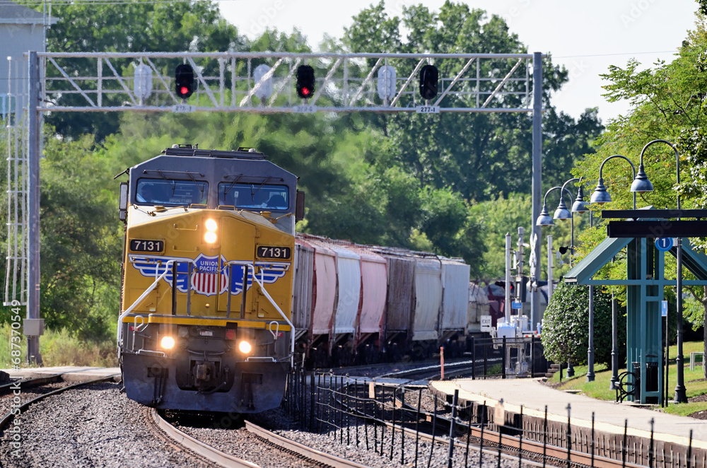 Multiple lead a Union Pacific freight train under a signal