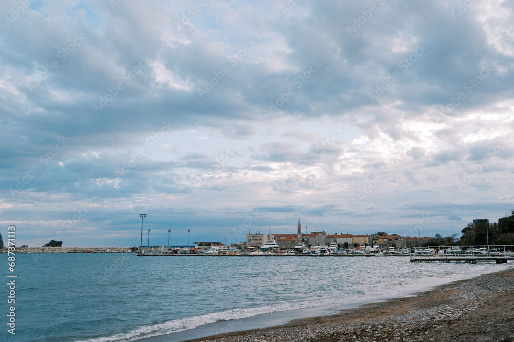 Resort town with a marina on the seashore against a cloudy sky