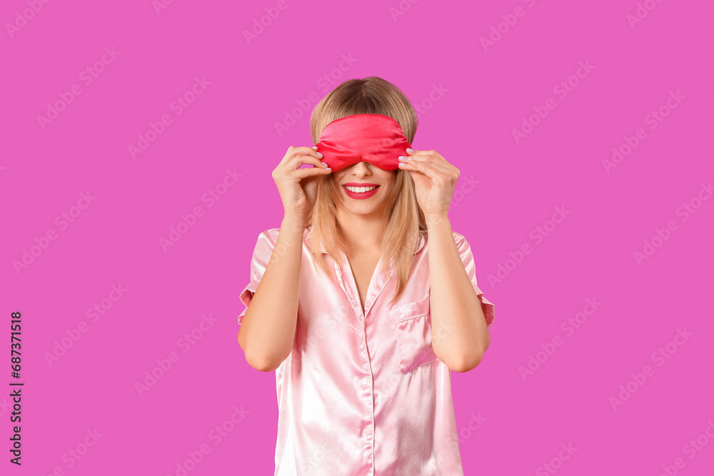 Young woman in pajamas with sleeping mask on purple background Young woman in pajamas with sleeping mask on purple background