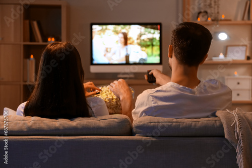 Couple with popcorn watchin...