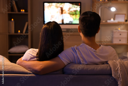 Couple watching TV at home ...