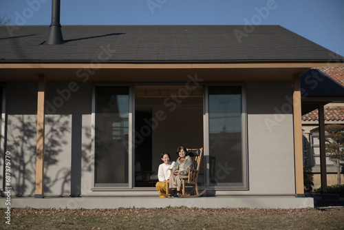 娘と母の高齢者介護の秋冬イメージ　仲良く会話する親子の広角 コピースペースあり photo