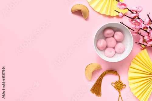 Bowl of tangyuan, fortune cookies, Chinese decor and sakura on pink background. Dongzhi Festival photo