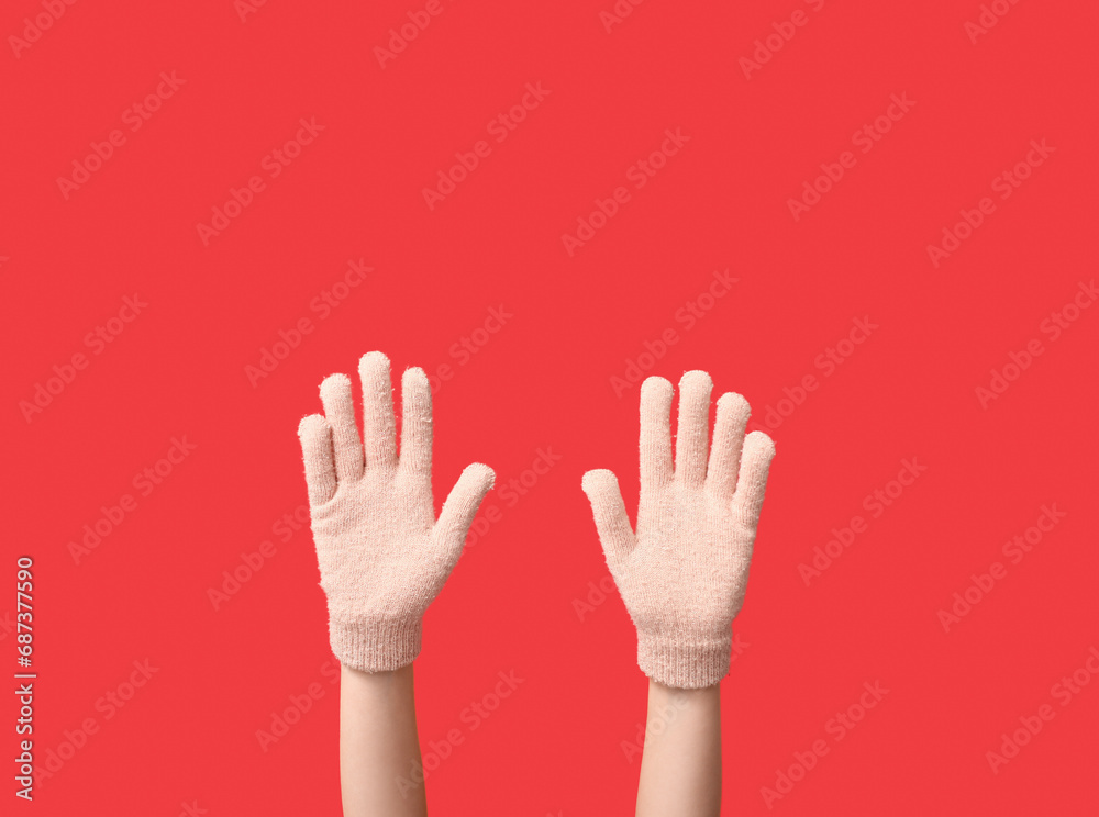 Obraz premium Hands in warm gloves on red background