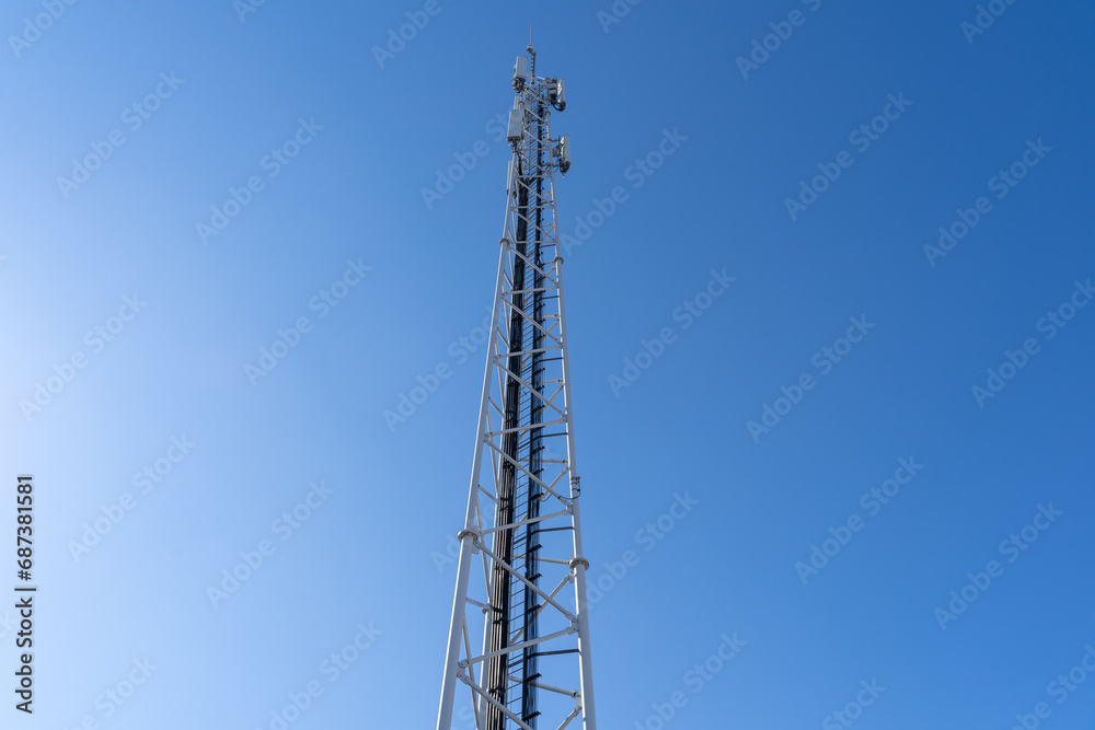 Phone and internet tower with antennas in the blue sky Phone and internet tower with antennas in the blue sky