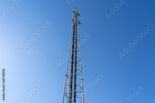 Phone and internet tower with antennas in the blue sky