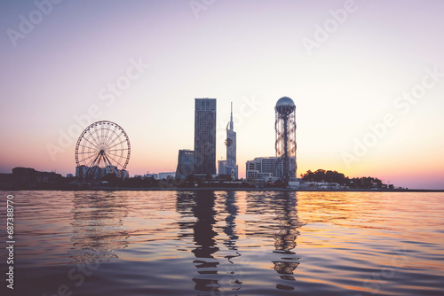 Iveria beach waterfront view with famous Batumi landmarks in the background: Chacha tower; Ferris wheel and alphabetic tower. Romantic holidays in Georgian vegas concept. photo