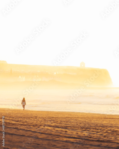 Young woman silhouette walking alone on scenic beach on sunset. Well being woman concept photo