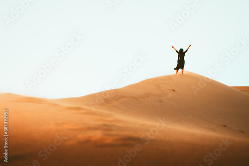 Solo woman stand on top dune enjoy panorama and sunset in Kashan desert in Iran