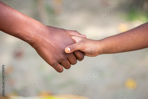 A man shaking hands with another kid and blurred background