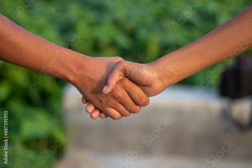 A man making handshake with another man and blur background