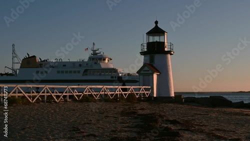 Steam Boat Ferry passing at Sunrise at Brant Point Lighthouse, Nantucket Island, Massachusetts, USA