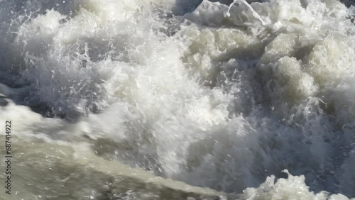Up and down drone aerial view of the a river swollen after heavy rains. The water flows quickly. Risk of flooding and overflow. General contest of a river flood