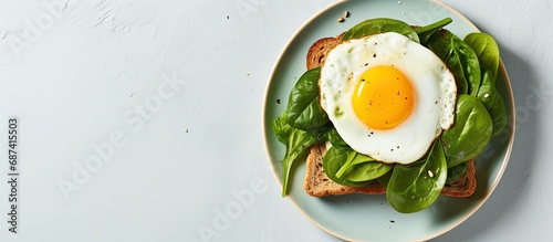 Avocado, spinach, fried egg on toast, viewed from above. photo