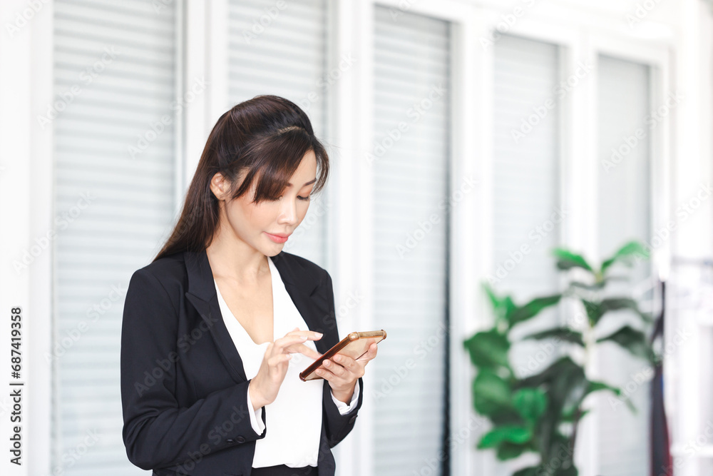 Portrait of young Asian woman taking break and use of smartphone, Beautiful young Asian woman using mobile phone in office Portrait of young Asian woman taking break and use of smartphone, Beautiful young Asian woman using mobile phone in office