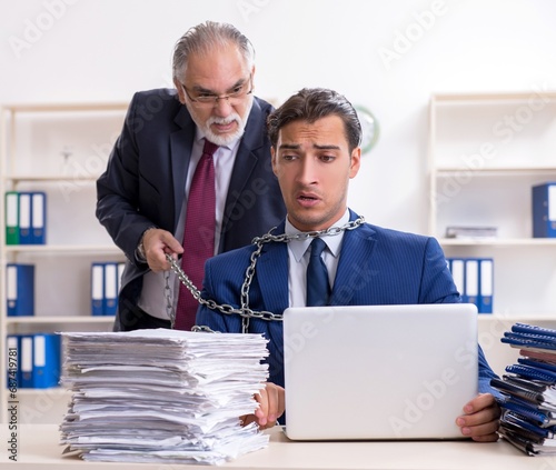 Old boss and young male employee in the office