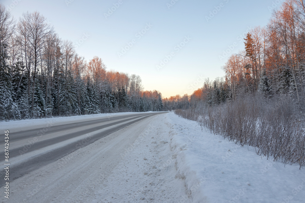 A winter road in the rays of the setting sun. Russia