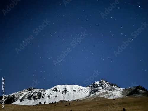 A sea of stars accompany this beautiful snowy mountain. photo