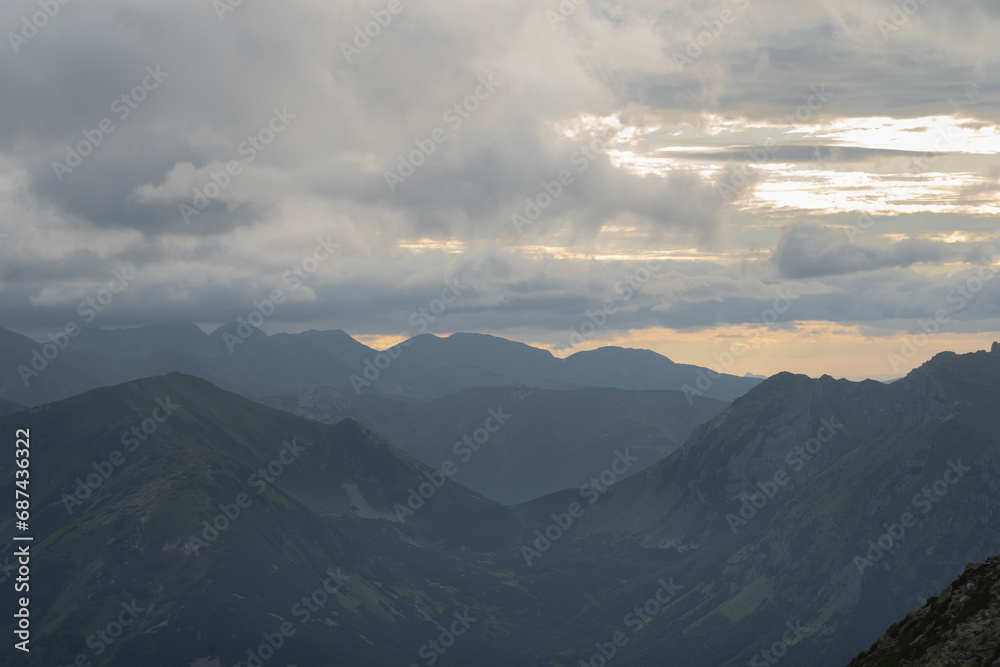 Mesmerizing mountain landscape high in the Polish Tatras at sunset through the clouds.