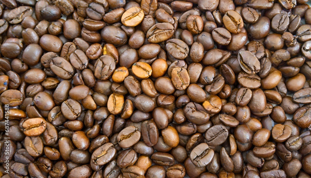 Close up of a bunch of coffee beans background top view; roasted dark brown coffe seeds Close up of a bunch of coffee beans background top view; roasted dark brown coffe seeds