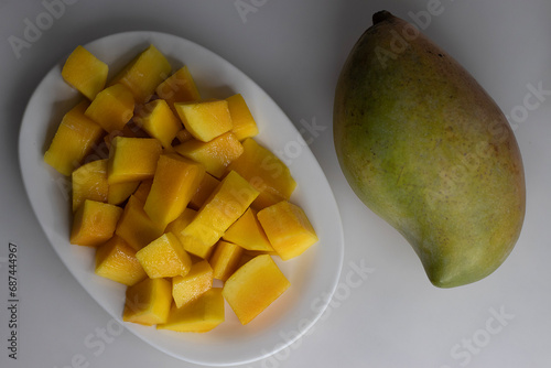 Fresh large totapuri mangoes sliced to small pieces, juicy and vibrant in color photo