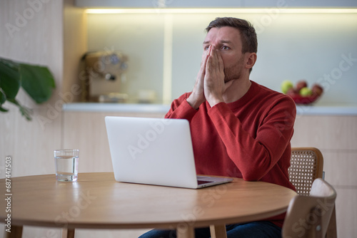 Canvas-taulu Unemployed hopeless man sitting at table in stress and depression because of money loss, dismissal, bankruptcy, job cut