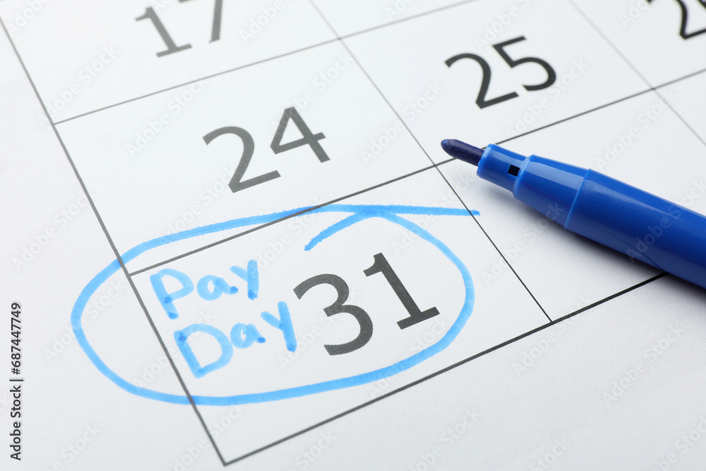 Blue felt pen on calendar page with marked payday date, closeup Blue felt pen on calendar page with marked payday date, closeup
