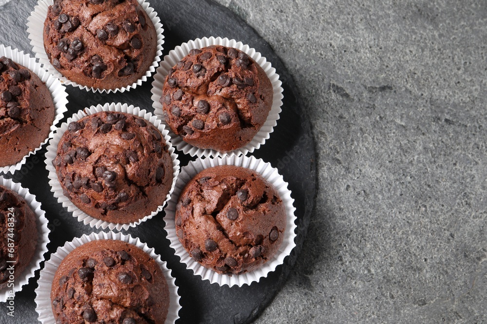 Tasty chocolate muffins on grey textured table, top view. Space for text Tasty chocolate muffins on grey textured table, top view. Space for text