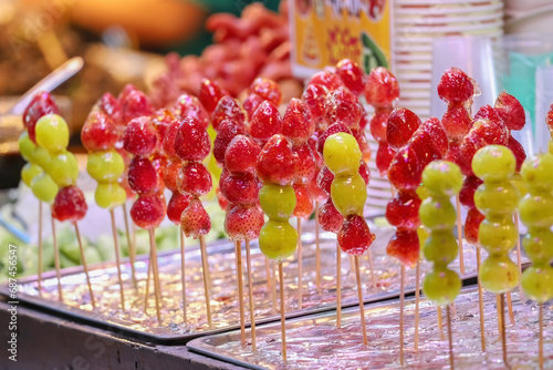 Skewers of sugar coated fruit
