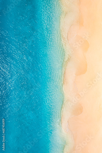 Summer seascape beautiful waves, blue sea water in sunny day. Top view from drone. Sea aerial view, amazing tropical nature background. Inspirational bright sea with waves splash crash and beach sand