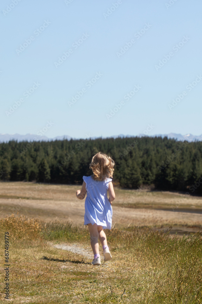Cute funny girl running around the field in a dress in summer. Childhood, holidays. Cute funny girl running around the field in a dress in summer. Childhood, holidays.