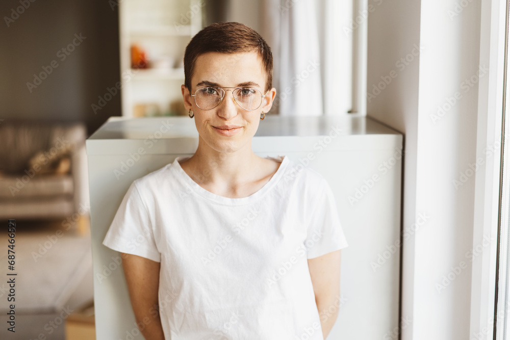 Confident Young Woman with Short Hair, Glasses, and T-Shirt, Gazing Intently in Contemporary Living Room Confident Young Woman with Short Hair, Glasses, and T-Shirt, Gazing Intently in Contemporary Living Room