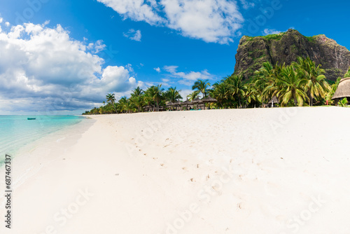Beautiful view of the tropical coastline on Mauritius. Ocean, sand, coconut palms and sky