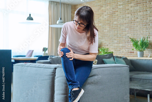 Middle aged woman suffering from knee pain photo