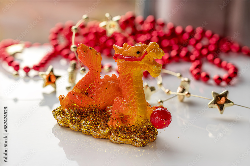 Fire Dragon symbol of year 2024. Dragon holding pearl. Figurine-mascot Chinese Dragon. Christmas decorations