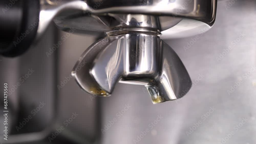 Close-up flowing fresh ground coffee. Pour coffee stream from the professional machine into the cup. Barista making double espresso with grinder oder filter holder. Drink a roasted black coffee Close-up flowing fresh ground coffee. Pour coffee stream from the professional machine into the cup. Barista making double espresso with grinder oder filter holder. Drink a roasted black coffee