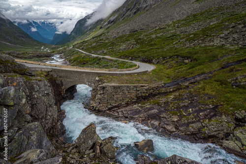 Glacier melt river flowing alongside road in the valley of Fjord in Norway during summer photo