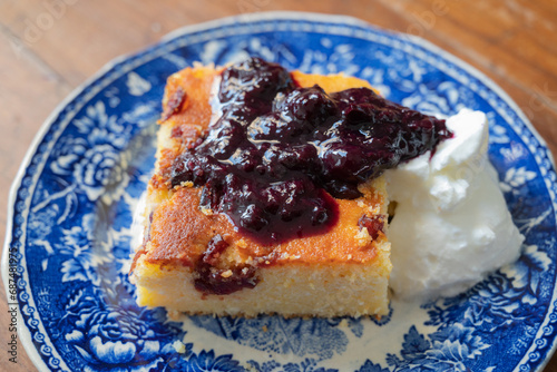 A slice of Malai, or alivenci, a cornbread-like cake from the Romanian cuisine, made with cornmeal and cheese, served with sour cream and blueberry jam photo