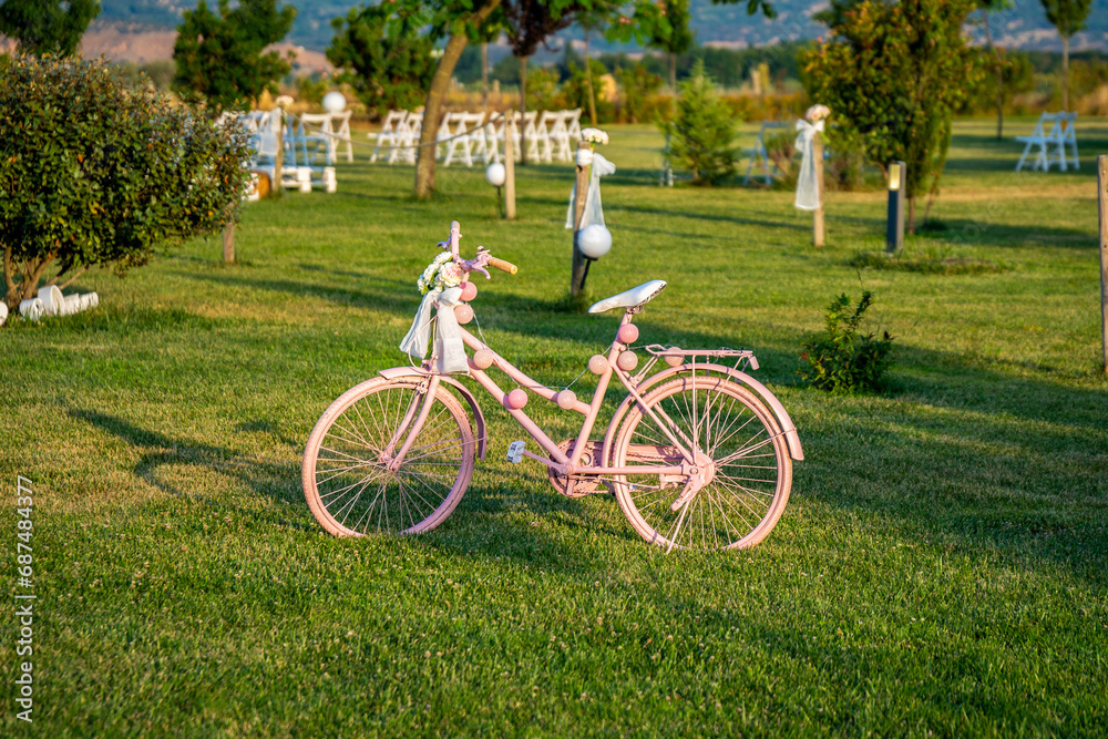 Bicicleta rosa sobre césped de finca de ceremonia